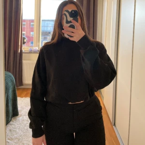 Svart sweatshirt - Svart basic sweatshirt från Nelly. Knytdetalj längst ner så man kan justera hur man vill att tröjan ska sitta. Passar en S eller M. Hel och ren.