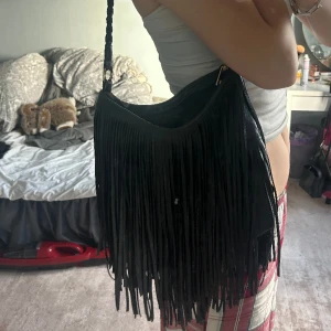 Väska med fransar  - Super fin. Dragkedjan är sönder men funkar ändå, perfekt till skolan även om dragkedjan inte funkar perfekt storlek! Köpt secondhand! 