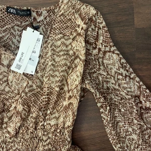 Zara klänning - Köpt förra vintern men helt oanvänd med lapp kvar. Det är en mönstrad volangklänning!