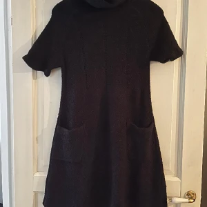 Klänning med polo - En polo klänning med fickor. Fin stickad utsvängd modell. 