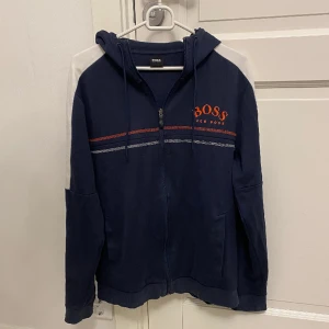 Hugo Boss hoodie - Väldigt fin Hugo Boss hoodie. Använt skick men har mycket kvar att ge, storlek L men sitter som M. Hör gärna av dig vid funderingar!