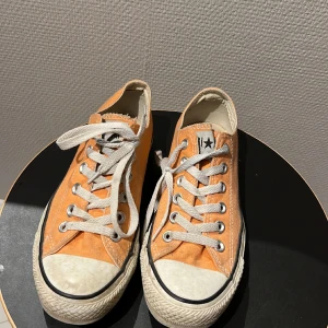 Converse - Låga converse i lite orange/korall färg i strl 38. Använda men i ganska bra skick, lite smutsiga, men går att köra i tvättmaskinen!