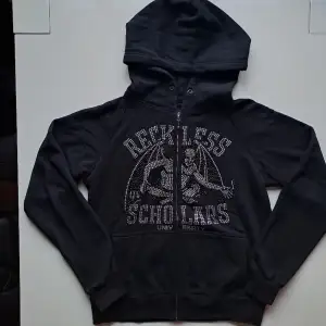 Varumärke: Reckless Scholars  Produkt: Zip hoodie   Material: 100% bomull   Storlek: S  Färg: Svart, silver  Kondition: Mycket bra begagnat skick   Mått: L: 64cm B: 56cm Kön: Herr/Unisex 