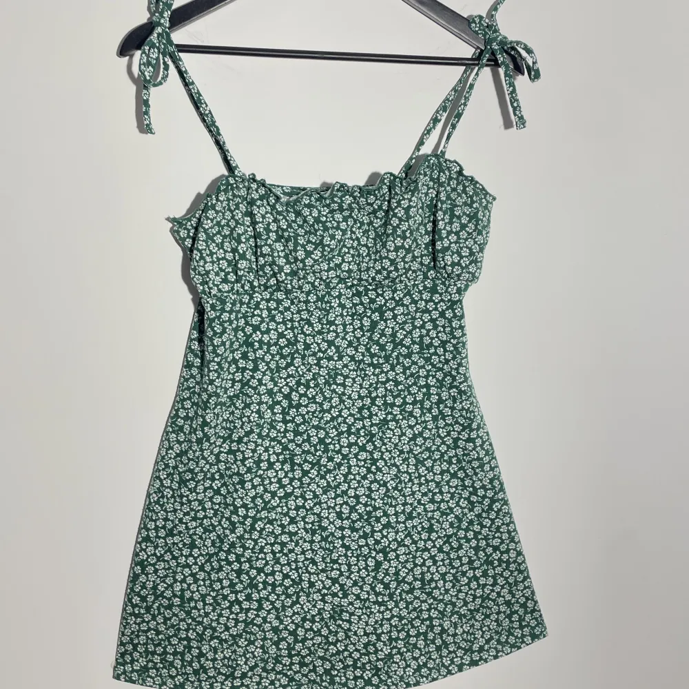 söt grön klänning med vita blommor från H&M! band som man knyter själv❣️. Klänningar.