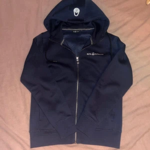 Sail racing Zip hoodie - Denhär hoodien är i storlek S och är i ett skönt material, köpt på stadium och skulle ge till min brorsa men den passade inte honom. Den har bara blivit på testad så den är inte använd. Ny pris ligger på 1,200kr.