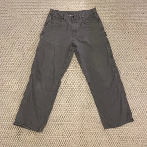 Grå cargo byxor - Gråa cargo byxor från carhartt Vit färg fläck på en av fickorna (bild 3) inget man stort sätt tänker på  Annars bra skick