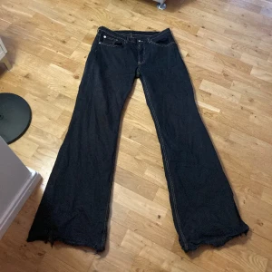 Bootcut jeans  - Ett par bootcut jeans från arket i bra skick, dock lite slitna längst ner (bild 3). Jeansen är egentligen blåa men är omfärgade till svarta. Riktig snygg gul stitching! Dam modell men passar herr också. Nypris ca 900.