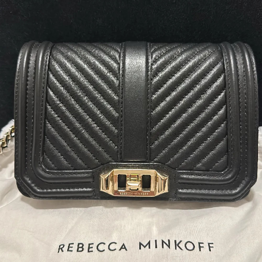 Rebecca Minkoff väska.  En mindre väska i fin kvalite med svart läderband med gulddetajer.  . Väskor.