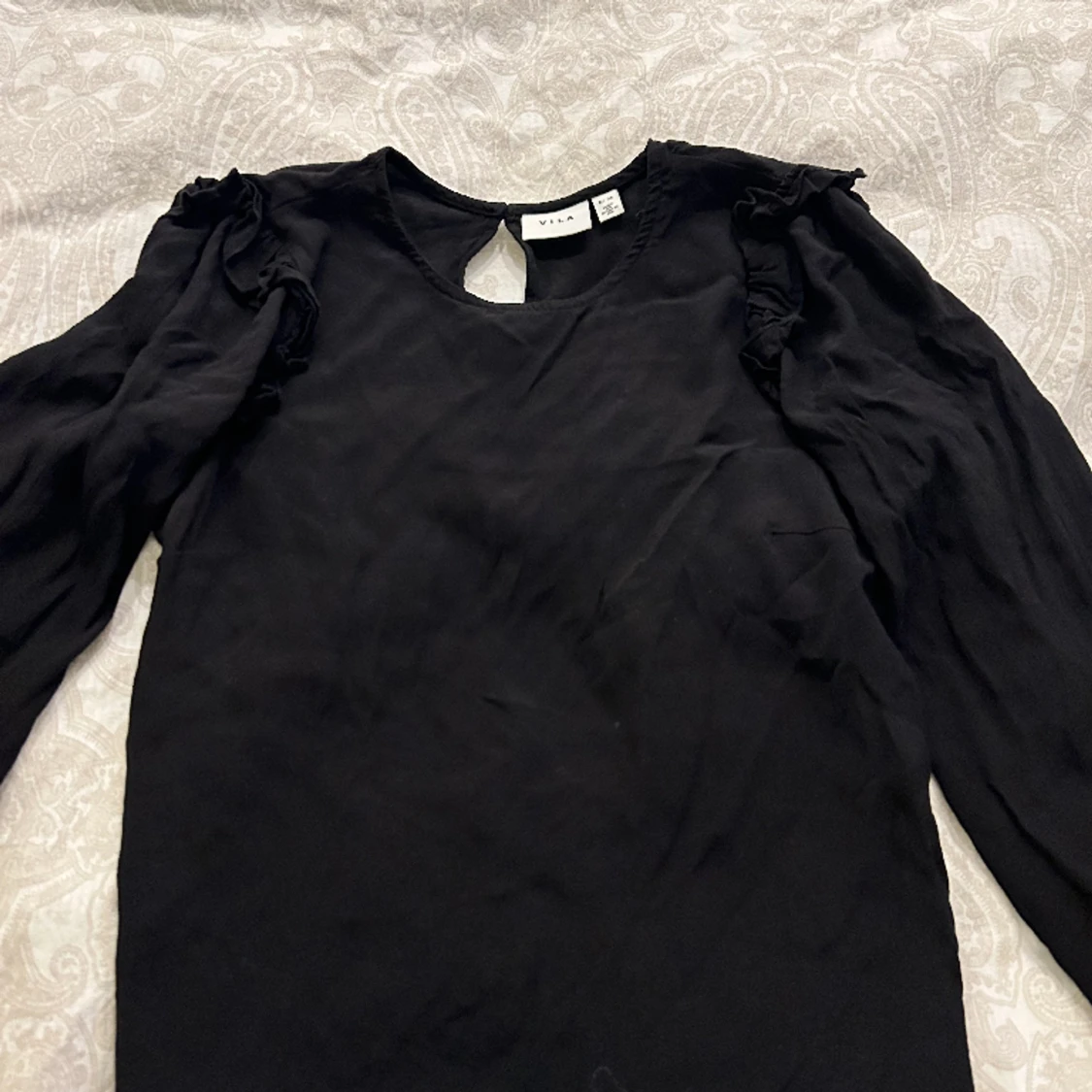 Svart blus med lite volang