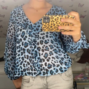 Blå leopardmönstrad blus - Superfin blå leopardmönstrad blus med volanger från Zara. Helt oanvänd med lappen kvar. Storlek L, men lite liten i storleken, passar S/M. Säljer då jag inte hann lämna tillbaka den. 