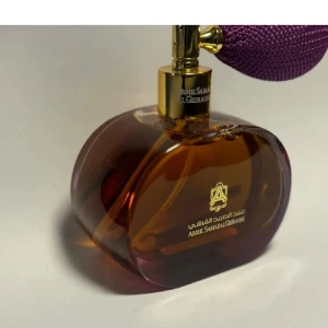 Parfym från Abdul Samad Al Qurashi - Säljer en lyxig OUD parfym från Abdul Samad Al Qurashi. Flaskan är elegant och har en vacker brun färg med en guldig topp och en lila pump. Perfekt för den som vill ha en exklusiv doftupplevelse. Flaskan har en unik form som gör den till en fin detal
