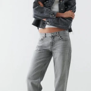 Grå croppad jeansjacka - Säljer en snygg grå croppad jeansjacka. Den har en klassisk design med knappar framtill och två bröstfickor. Perfekt för en casual look och passar bra till både jeans och kjol. Jackan är i bra skick och redo för en ny ägare!