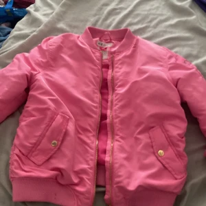 Bombarjacka - Super fin rosa bombarjacka, använde en gång på en uppvisning sen aldrig  använd mer storlek 140 (9-10 år) köpte för typ 350 så inte så mycket billigare men den e ju aldrig använd ich  