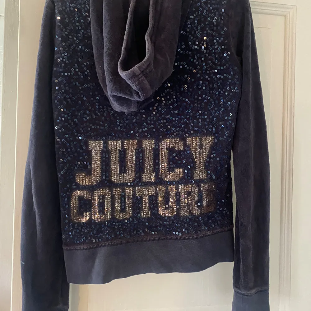 Säljer en snygg mörkblå hoodie från Juicy Couture i storlek XS. Den har en dragkedja framtill och en ficka fram. På baksidan finns det glittriga paljetter som bildar texten 'Juicy Couture'. den ä väl använd men ändå fin💙. Tröjor & Koftor.