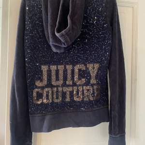 Säljer en snygg mörkblå hoodie från Juicy Couture i storlek XS. Den har en dragkedja framtill och en ficka fram. På baksidan finns det glittriga paljetter som bildar texten 'Juicy Couture'. den ä väl använd men ändå fin💙