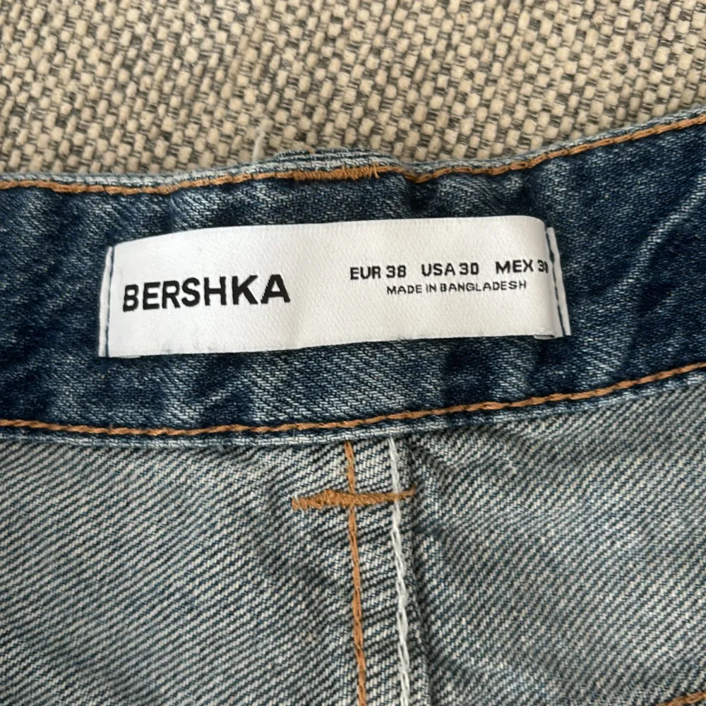 Säljer ett par snygga blå jeans från Bershka. Tvättad blå färg. Jeansen har en dragkedja och knapp framtill. väldigt baggy och oversize💕. Jeans & Byxor.