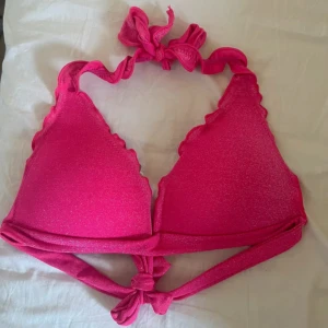 Rosa glittrig bikiniöverdel - Säljer en superfin rosa glittrig bikiniöverdel i storlek S. Den har knytband både runt nacken och ryggen, vilket gör att den sitter perfekt. Perfekt för sommarens alla bad och strandhäng! 💖