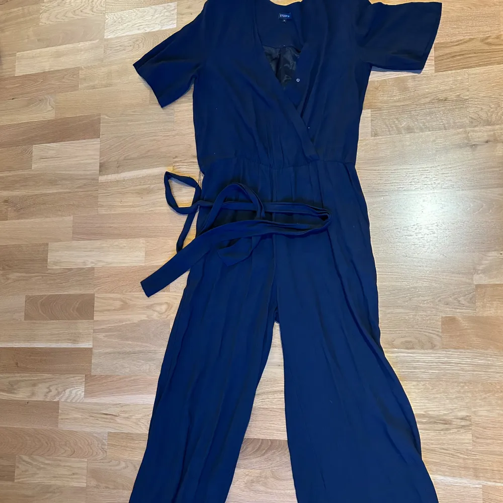 Storlek: 36 En marinblå jumpsuit från Stockoh lm med fickor på vardera sida samt snöre som man kan knyta runt midjan. Använd ett fåtal gånger. Köparen står för frakten  . Klänningar.