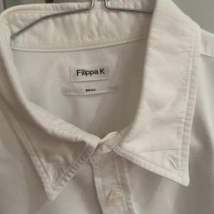 Vit skjorta Filippa K storlek Small - Vit skjorta från Filippa K Mycket fint skick, använd enbart enstaka gång! Skjortan tvättad och pressad på kemtvätt inför försäljningen  Storlek: Small men något stor i storleken, hade passat till Medium också (43cm bred och 74cm lång) 100% bomull