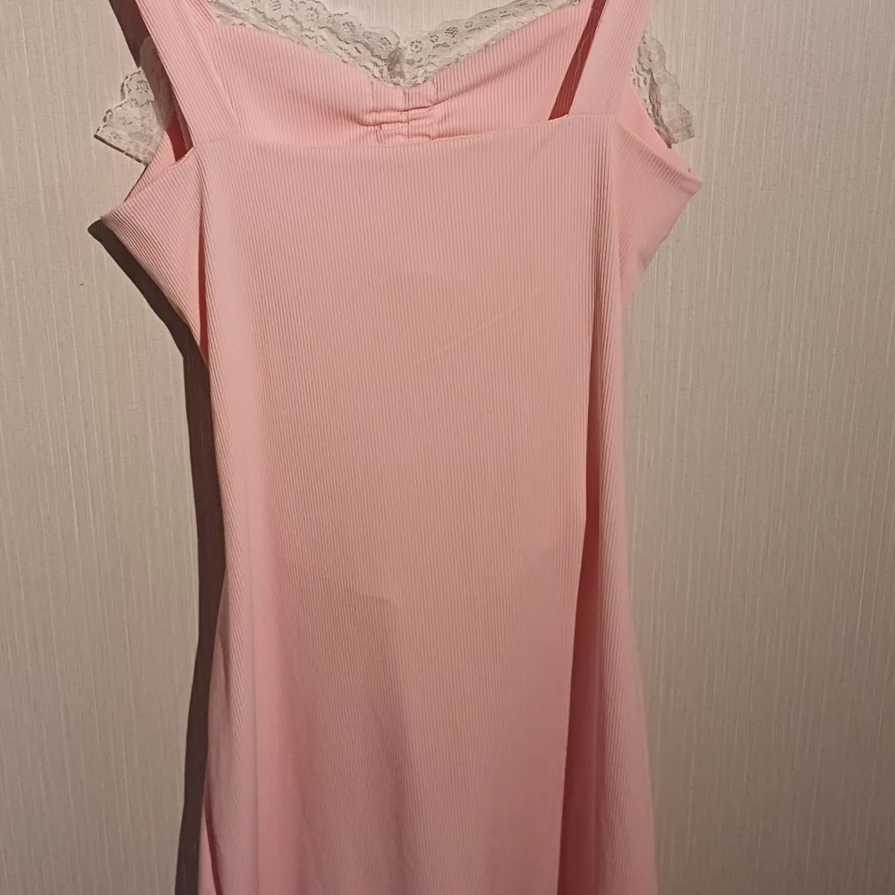 Superfin rosa klänning med lite spets och en rosett🎀 Hittar ingen lapp så vet ej märket eller storlek men tror att de är en s kanske en medium, stretchigt material  Fler bilder kan fås och kontakta mig gärna innan köp då jag säljer på fler sidor🤍. Klänningar.