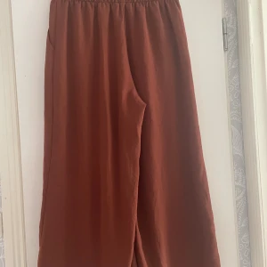 Bruna vida byxor! - Ett par luftiga brun/röda byxor från H&M i strl: 40 De har varit använda men är i bra skick!  Säljer pga passar mig inte Skriv gärna med frågor, eller för fler bilder!