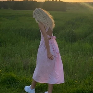 Rosa långklänning med öppen rygg  - Säljer denna rosa långklänning som har en öppen rygg med snörning. Väldigt bra skick och i strl s. Säljer för 150kr