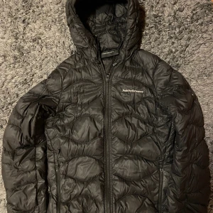 Peak performance XS - Säljer en väldigt fin Peak Performance Helium dunjacka. Alla dragkedjor är hela och fungerar (även på fickorna). Så jätte fin men ett litet rivmärke (se andra bilden) så betyg 8/10. Säljer den då den är för liten. Väger bara 250gr så porto är billigt