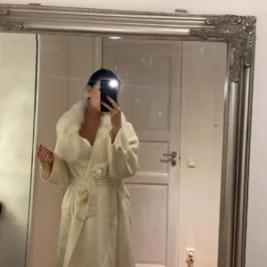 Ullkappa  - Säljer min vita Ullkappa med äkta pälskrage till. Kemtvättad och klar.