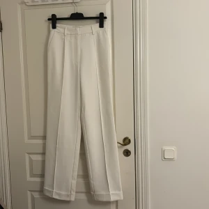 Hanna Schönberg x Na-Kd kostymbyxor - Vita kostymbyxor från Hanna Schönbergs kollektion med Na-Kd i storlek 34. Superfina och med innertyg så att de känns ordentliga och syns ej igenom. Pris kan diskuteras!
