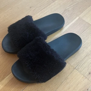 Tofflor  - Svarta tofflor med ”päls” framtill. 