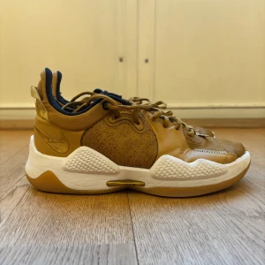 Nike PG 5 EP ’Wheat Metallic Gold’  - Säljer mina PG 5’s!! Super sköna o bra grepp, knappt använda. Har dock fått en liten skada på baksidan av vänstra skon (se bild 3) Säljs pga att jag har slutat spela basket (tryck gärna på köp nu) - retail priset är 142-417 USD$🏀