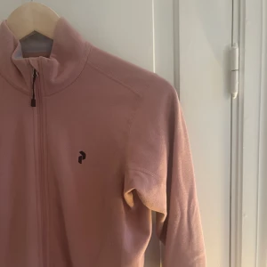 Peak performance fleece  - Säljes då jag ej använder den tillräckligt. Är i gott skick.  Färgen var lite svår att fånga på bild - skulle bäst beskriva fleecen som gammalrosa 