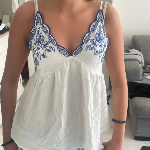 Jättefin sommar topp - Säljer detta jättefina linne med blåa detaljer💕 säljer pga att jag inte får någon användning av det. Köpt på tj max i USA förra året. Använd 1-2 gånger så den är som ny💕strl m men passar som s också. pris kan diskuteras!