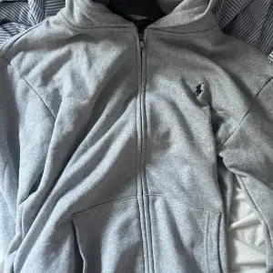 Grå Polo Ralph lauren zip hoodie i storlek M, inte använd mycket så syns knappast att den är använd. Nypris 2100kr säljer för 1050