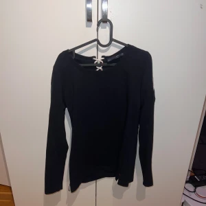 Svart långärmad tröja från Pelle P - En svart långärmad tröja från Pelle P i storlek L. Tröjan har en snörning vid nacken med vita snören och metallöljetter. Inköpt i Smögen på Pelle p butiken 