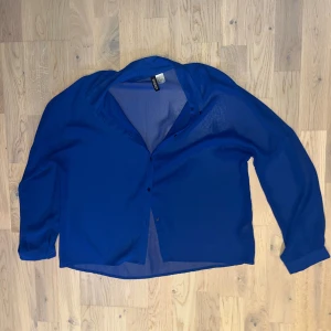Blå skjortblus - Blås skjortblus i ett lite genomskinlig material. Aldrig använd. 
