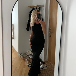 Fishtail klänning  - Svart maxi klänning från Nakd med ”fishtail”, använd vid ett tillfälle. Knytning runt nacken 