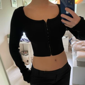 Svart topp - Svart topp med ”hakar” framtill