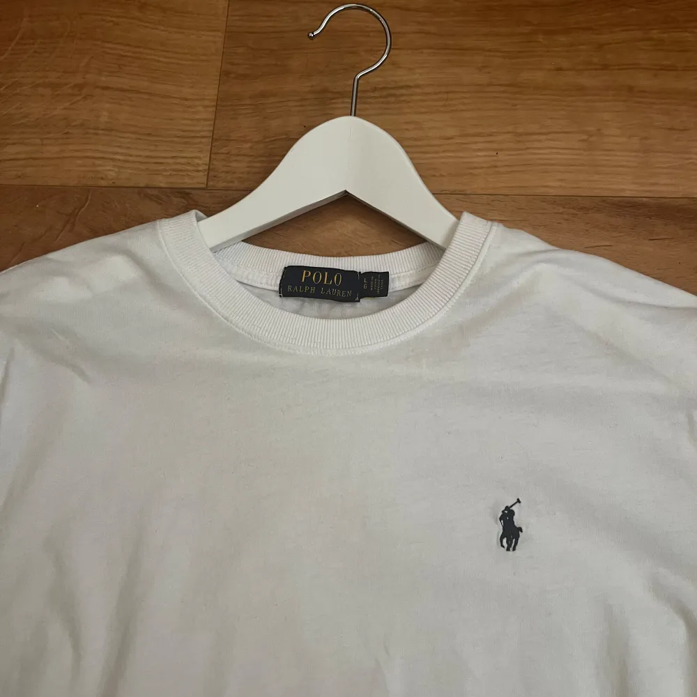 En klassisk vit t-shirt från Polo Ralph Lauren med korta ärmar och rund halsringning. T-shirten har en broderad logotyp på bröstet. Hör gärna av er om ni har några frågor eller bud! . T-shirts.