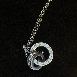 Halsband - Silver halsband i rostfritt stål. Använd fåtal gånger och är i nyskick! Säljer då jag använder guld. Har fina detaljer med romerska siffror och diamanter!