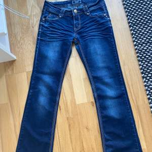 Lågmidjade bootcut jeans i en mörkblå färg. Snygga bakfickor med mönster. Passar xs-s