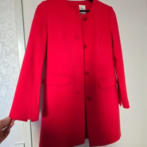 Holly & Whyte röd kappa - En snygg röd kappa med knappar framtill.  Oanvänd men utan etikett.