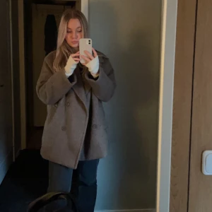 Brun jacka - Brun jacka/kappa från NAKD. Köpt för några år sedan. Är lite oversized i modellen. Är i bra skick men ena fickan har släppt i sömmen i kanten men inget som syns när man har på sig den. Enkelt att sy igen. 