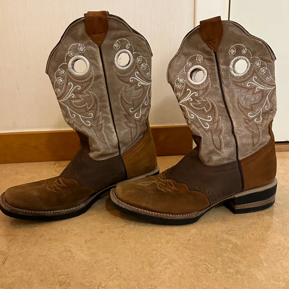 Superfina cowboy-boots i äkta läder 🤠👢👢🐎 Storlek 39. Några trådar har släppt vid de runda hålen (vilket nig lätt kan fixas om en vill det), annars i gott skick då skorna är sparsamt använda ✨. Skor.
