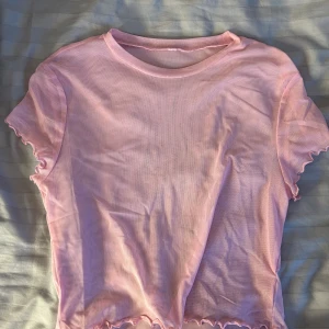 Rosa mesh-top - En ljusrosa topp i meshtyg. Från h&m, okänd storlek men liten och croppad.
