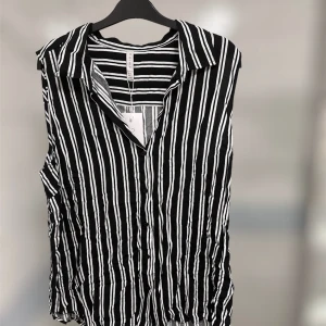 Kortärmad skjorta  - Randig svartvit skjorta i skön material. Den är från New Yorker i storlek XXL men skulle säga att den är M/L. Prislappen är kvar!