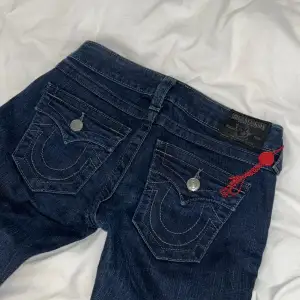 Extremt unika lågmidjade True Religion jeans. Endast använda en gång !Nyskick!  Innerbensmått: 86cm. Midjemått mätt rakt över: 34cm. Gylf: 17cm