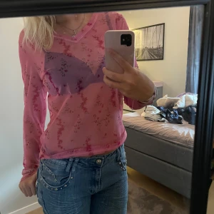 Genomskinlig rosa topp! - Rosa topp med blommor, den är v-ringad och i gott skick, står ingen storlek eller märke men skulle säga att den är storlek S (Byxorna på bilderna ligger också uppe)