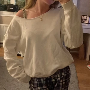 Vit långärmad tröja - En vit långärmad tröja med en lös passform. Tröjan har en bred halsringning och ribbstickade muddar vid ärmslut och nederkant.