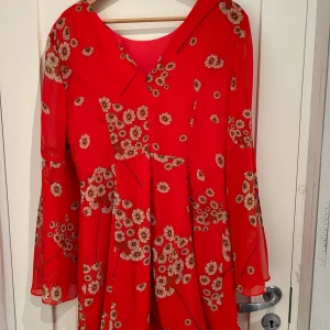 Röd/orange klänning ASOS - Fint skick. Liten i storleken mer som en stl 38. Chiffongklänning med vida ärmar och djupare rygg. Skater modell.